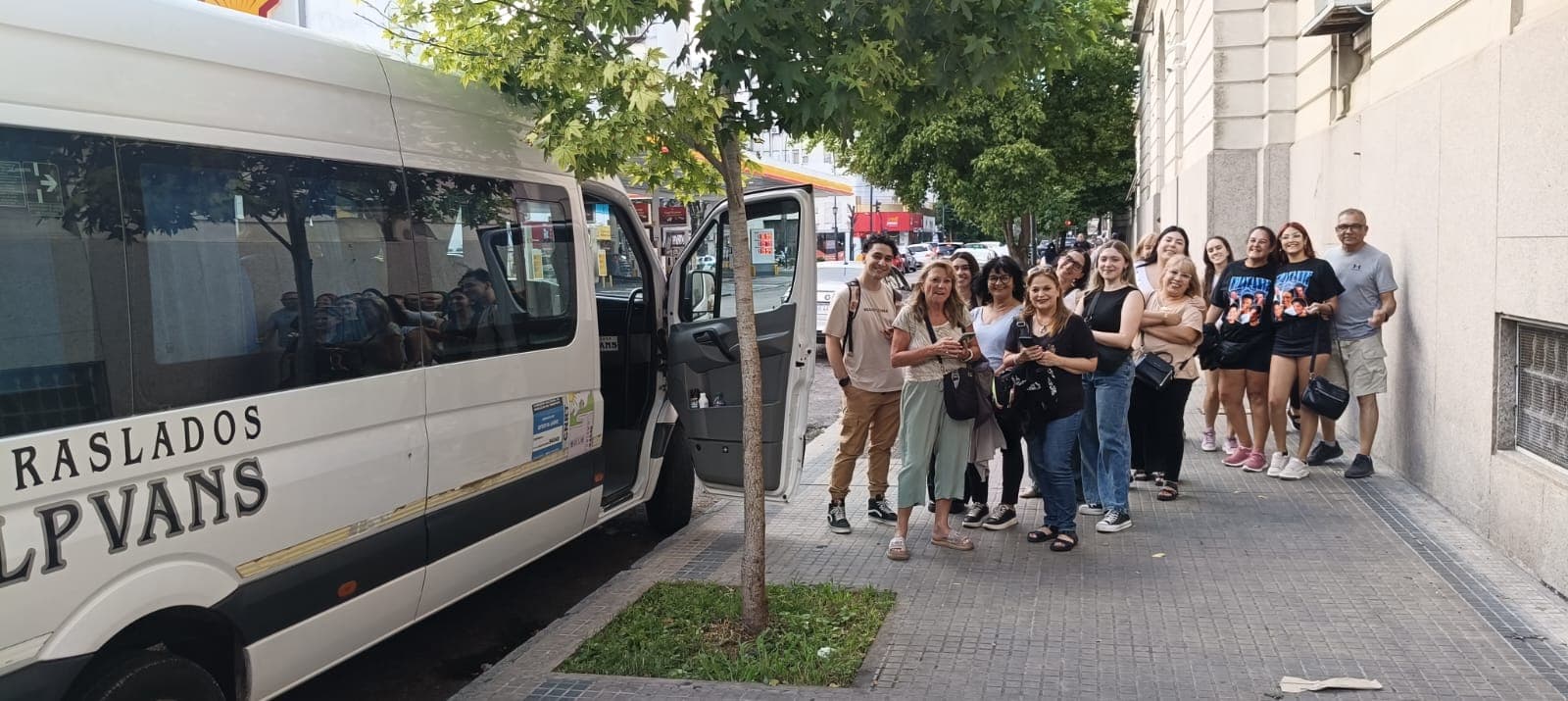 Pasajeros posando junto a la combi LP Vans en la calle
